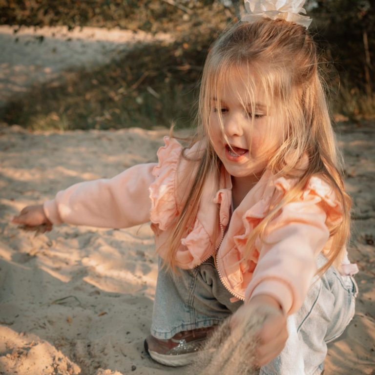 Meisje spelend in het zand. Kinderfotografie